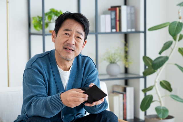 財布を持って困った顔の男性
